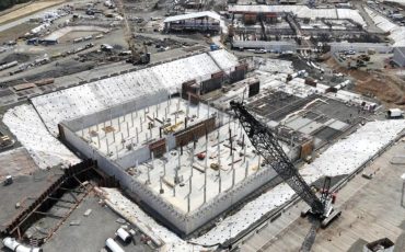 Aerial view of the Bull Run filtration facility under construction with concrete walls, formwork, and a crawler crane, Oregon